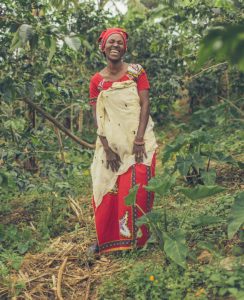 A Rwandan woman is in the forest laughing with joy