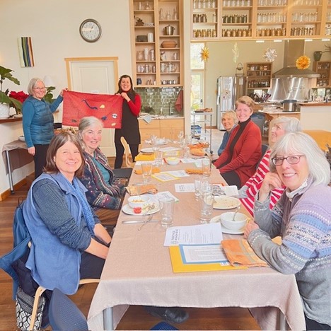 Members of the Spokane WA Chapter sit around a table creating a craft for featured grantee, Flying Kites