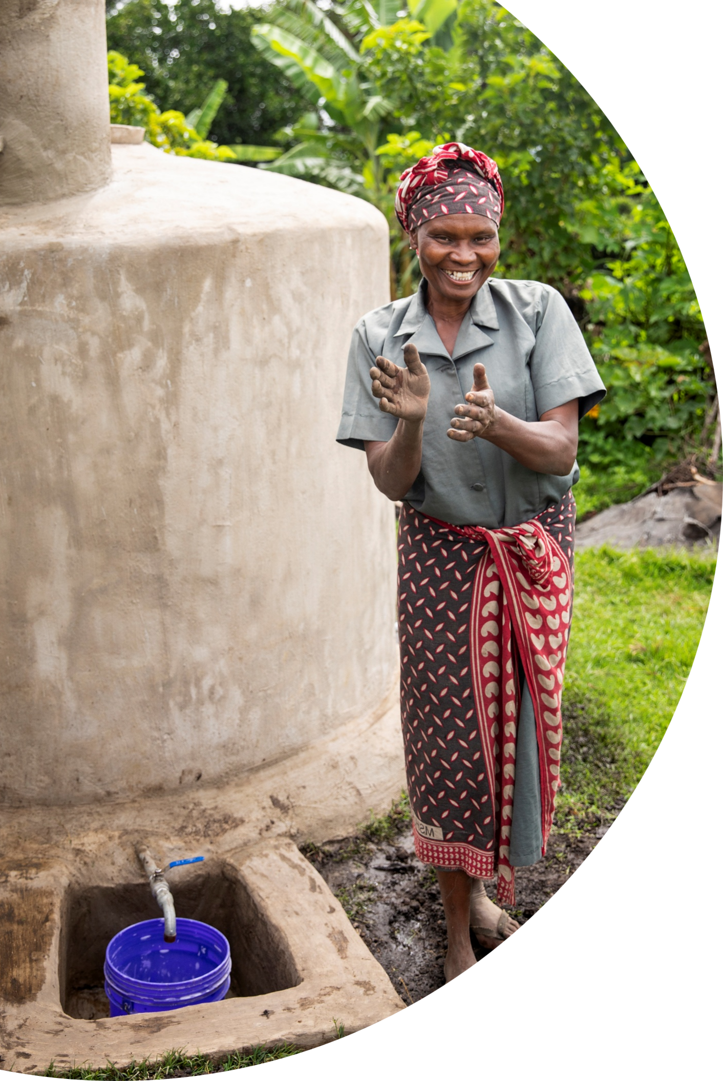 women clapping next to rainwater harvesting system